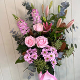 Bouquet of pink and green flowers with a white wooden background