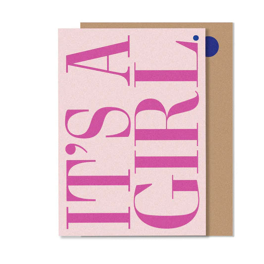 A greeting card with 'It's a girl' text in bold pink letters on a white background