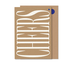 A beige greeting card with the word 'CHEERS' written in a large, cursive, white font on the front cover.