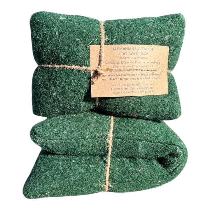 Two green heat-cold packs tied with twine on a white background