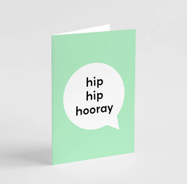 A green greeting card with the text 'hip hip hooray' in a white bubble on the front.