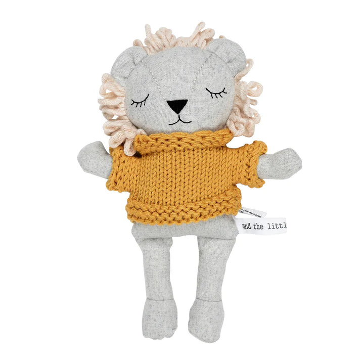 A plush toy depicting a lion wearing a mustard-colored jumper, made with soft cotton and wool blend fabric.