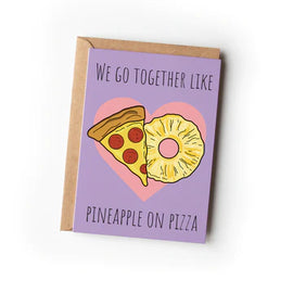 A greeting card with a purple background featuring an illustration of a pineapple and a slice of pizza with the text 'We go together like pineapple on pizza'.