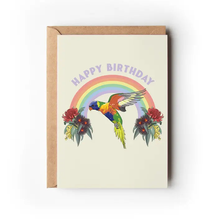 A greeting card with a colorful illustration of two black cockatoos, a rainbow, and flowers on a beige background, with the text 'Happy Birthday'.