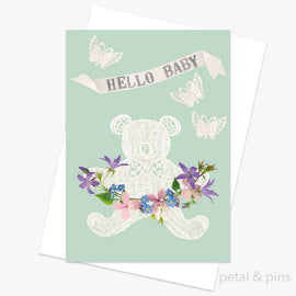 Greeting card with lace teddy bear and flowers on a light green background