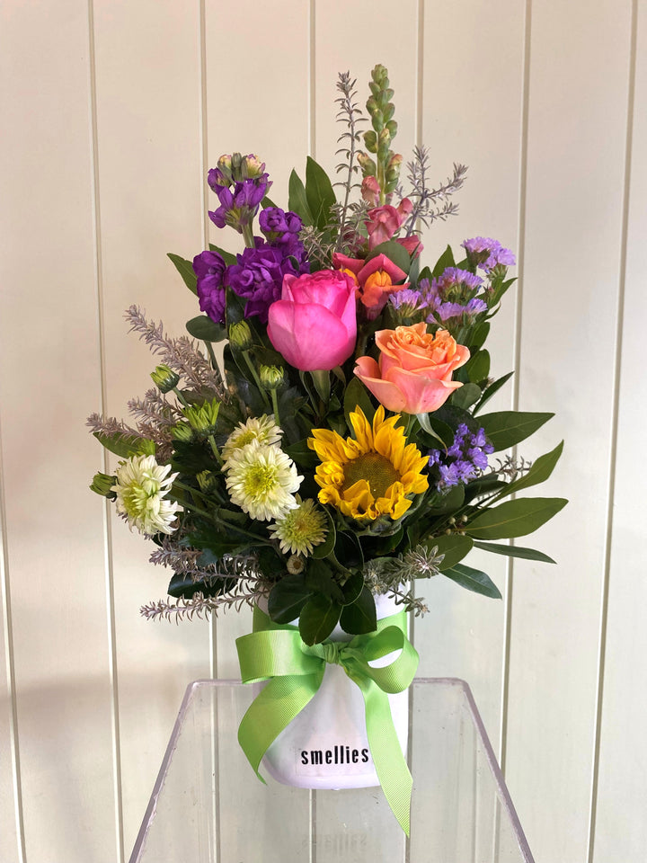 Bouquet of colorful flowers with a Smellies label on a white background