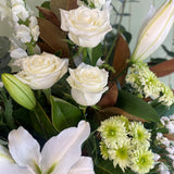 Bouquet of white roses and green flowers with a blurred background