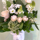 Close up of white flowers in a small white vase