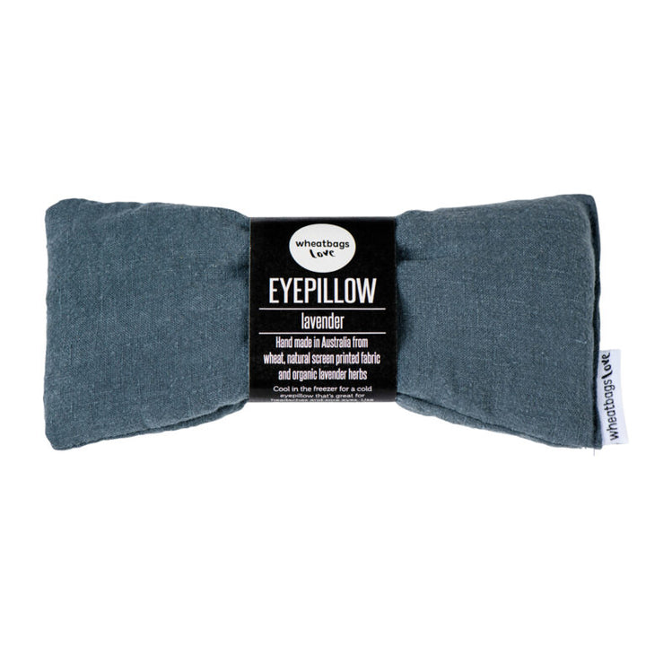 A rectangular eye pillow in a slate grey color, branded 'Wheatbags Love', with a label indicating it is scented with lavender and made from linen.