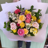 A beautifully arranged bouquet of colorful flowers presented with white wrapping paper