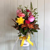 Colorful flower bouquet i a vasewith a yellow ribbon on a white background