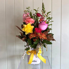 Colorful flower bouquet i a vasewith a yellow ribbon on a white background