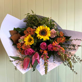 Bouquet of flowers with sunflowers and roses on a light green background