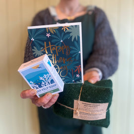 Person holding a box of soap, a bag of felt, and a card with 'Happy Father's Day' text.