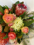 Bouquet of protea flowers with greenery on a white background