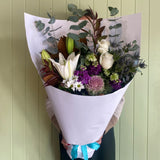 Bouquet of flowers wrapped in white paper with a green background
