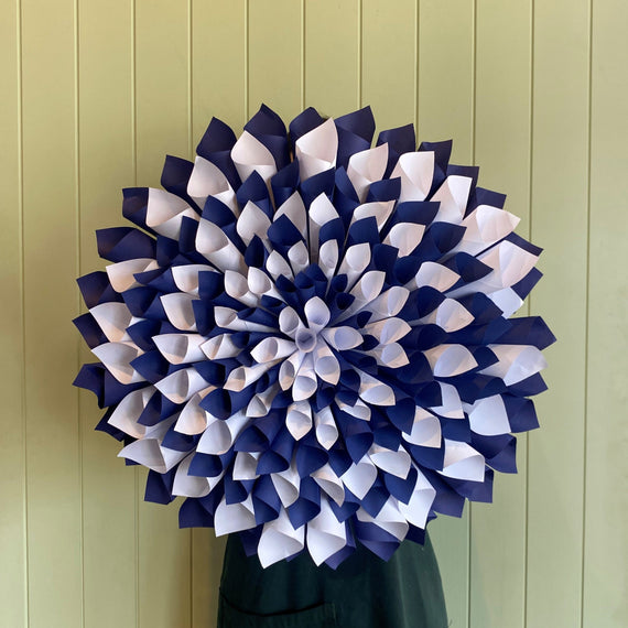Decorative wreath with blue and white flowers on a green door.