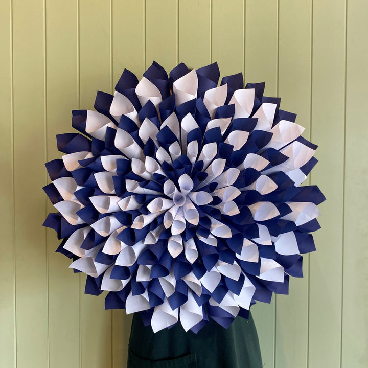 Decorative wreath with blue and white flowers on a green door.
