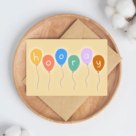 Colorful balloons drawn on a cream background with a letter in each that spells out hooray.