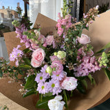 Bouquet of soft pink and pale lilac flowers in brown paper