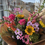 Bouquet of colourful, bright flowers in brown paper wrap