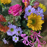 Bouquet of colourful flowers including sunflowers, roses, and chrysanthemums.