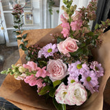 Bouquet of pink and white flowers in brown paper