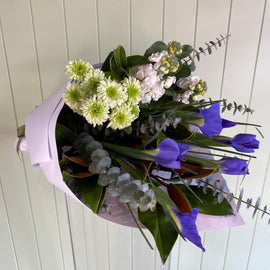 Bouquet of flowers in blue against a mint panelled backdrop