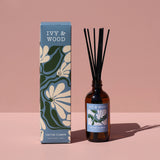 Ivy & Wood diffuser bottle and packaging on a pink background