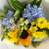 Bouquet of flowers with blue, yellow, and green colors on a white background
