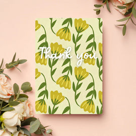 Graphic of yellow flowers on a light green background with the words Thank you in white in script across the front