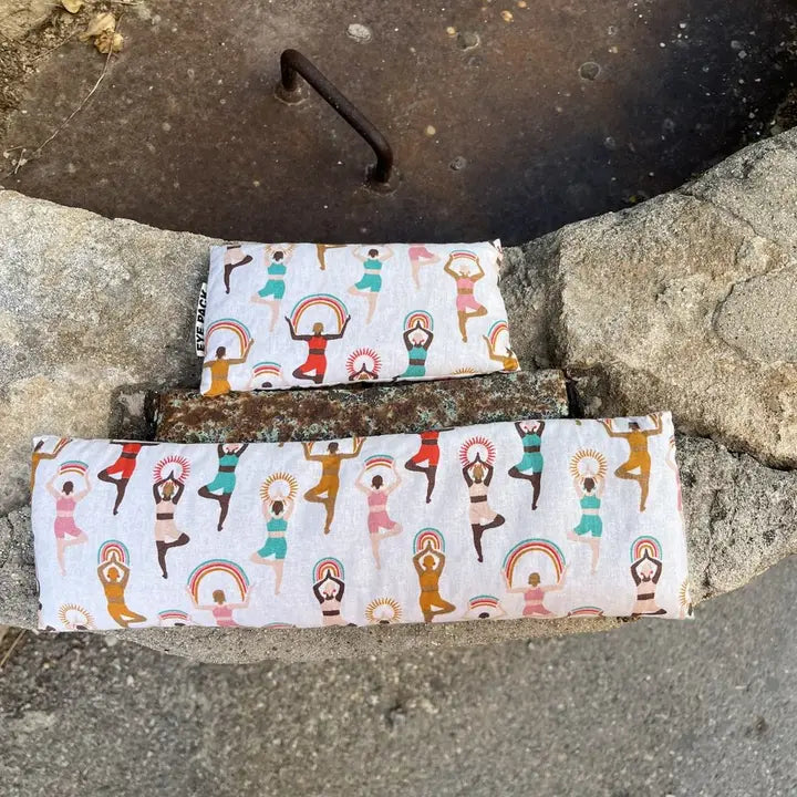 Two fabric wraps with yoga pose design on a stone surface