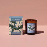 IVY & WOOD candle and packaging on a pink background