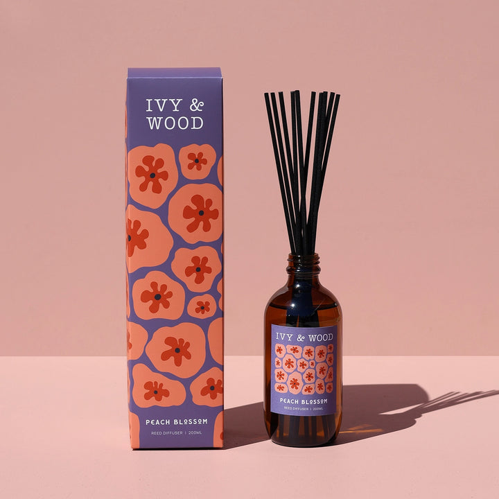 Ivy & Wood diffuser bottle and packaging on a pink background