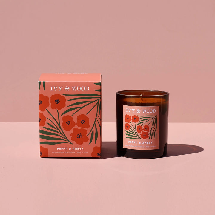 IVY & WOOD candle and packaging on a pink background