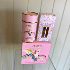 Monista tea packaging including a canister and boxes on a white background